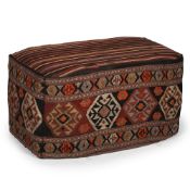 A KILIM UPHOLSTERED OTTOMAN OR FOOTSTOOL, THE KILIM LATE 19TH OR EARLY 2OTH CENTURY