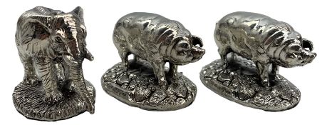 Pair of modern miniature silver pig ornaments on oval bases L5cm and another of an elephant L5cm all