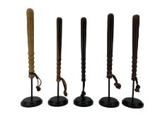 Five turned wooden truncheons with leather wrist straps