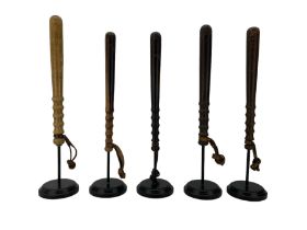 Five turned wooden truncheons with leather wrist straps