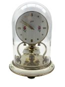 Small 20th century Schatz torsion clock with a decorative dial under an acrylic dome.