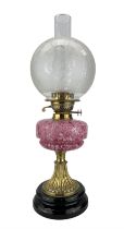 Victorian brass oil lamp with pink mottled glass reservoir