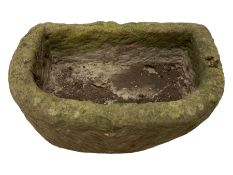 Small D-shaped weathered stone trough