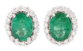Pair of 18ct white gold oval cut emerald and round brilliant cut diamond cluster stud earrings