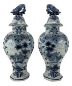 Pair of 20th century Delft vases and covers decorated in blue with figures in rural landscapes