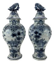 Pair of 20th century Delft vases and covers decorated in blue with figures in rural landscapes