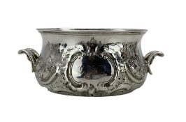 Victorian silver circular sugar bowl with embossed floral decoration and shaped handles