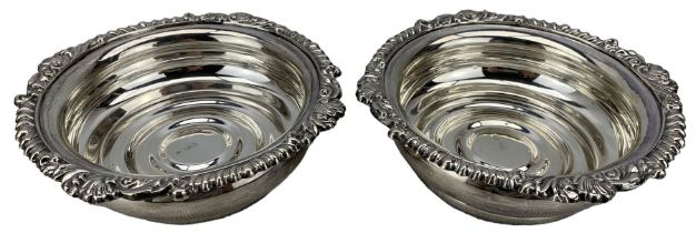 Pair of silver bottle coasters with gadrooned and shell moulded borders on a wooden base D16cm