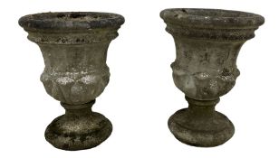 Pair of weathered cast stone two-piece garden urns