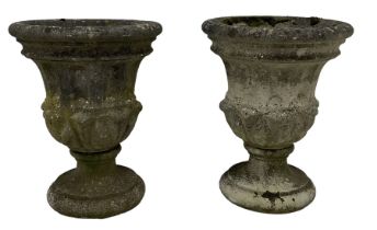 Pair of weathered cast stone two-piece garden urns