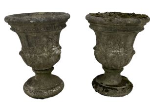 Pair of weathered cast stone two-piece garden urns