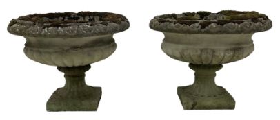 Pair of weathered cast stone garden urns