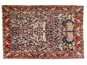 Persian indigo and crimson ground rug