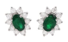 Pair of 18ct white gold oval cut emerald and round brilliant cut diamond cluster stud earrings