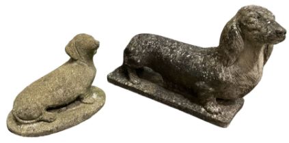 Two weathered cast stone statues of Dachshunds on bases