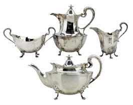 Silver four piece tea set of panel sided oval design raised on four shaped supports comprising teapo