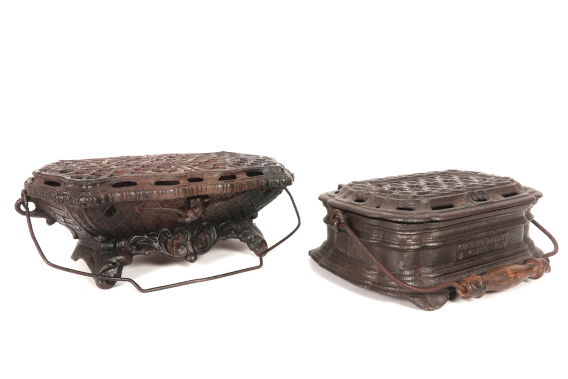 two antique feet-warmers in cast iron || Lot van twee antieke voetstoven in gietijzer