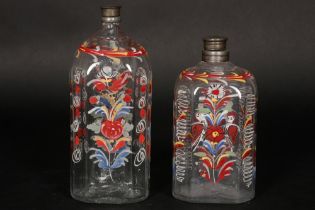 two antique, presumably German, bottles in clear glass with polychrome enamel paintings || Lot van