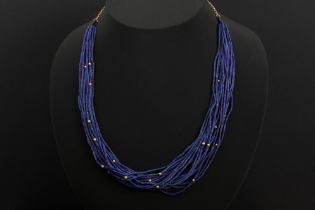 necklace with 20 strings of beads in lapis lazuli and some in gold & with a chain in yellow gold (18