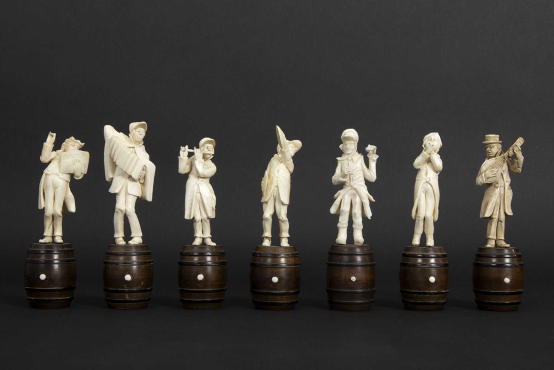 set of seven small antique figures in ivory, each standing on a wooden barrel - depicting a band - Image 2 of 6