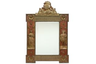mirror with an antique wooden frame with figures and ornaments in embossed brass || Spiegel met