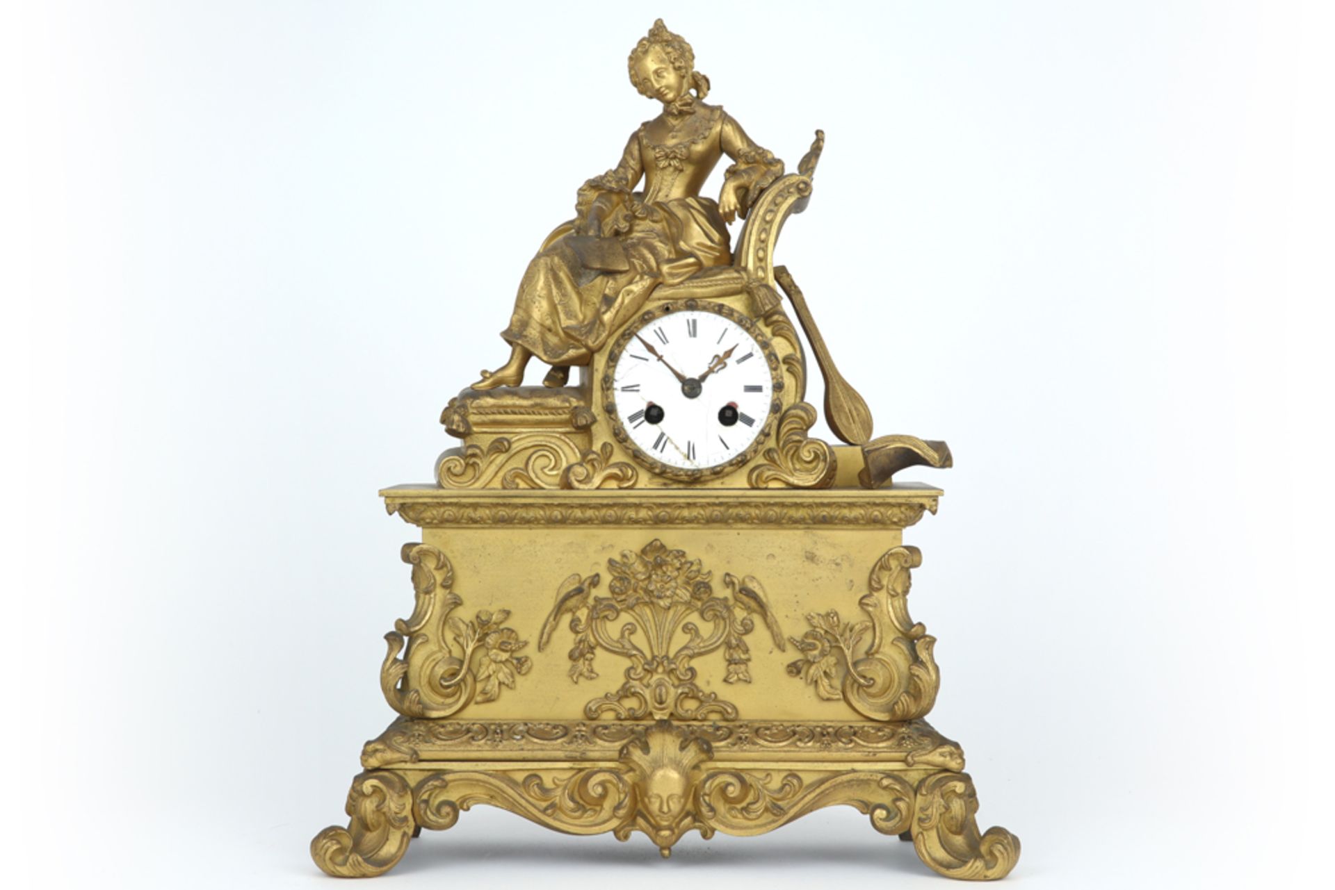 antique clock with its case in gilded metal || Antieke klok met kast versierd met een zittende vrouw