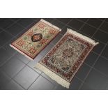 two small hand knotted rugs in silk amongst which a Persian Qom || Lot van twee kleine handgeknoopte