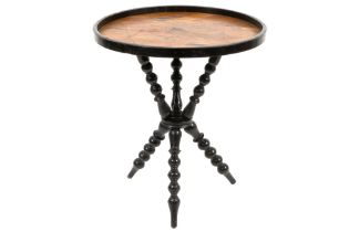 antique occasional table with a round parquetry top on a base with three crossed legs in ebonized