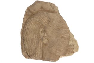Ancient Egyptian New Kingdom limestone wall sculpture with the representation of the head of a god