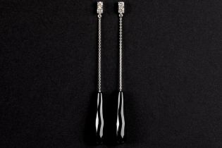 pair of quite long earrings in white gold (18 carat) with onyx drops in briolet cut and with 0,40