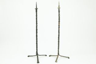 two quite big candlesticks in wrought iron || Lot van twee vrij hoge kandelaars met driepikkelpoot