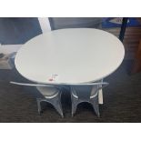 White circular table with two industrial style grey metal chairs