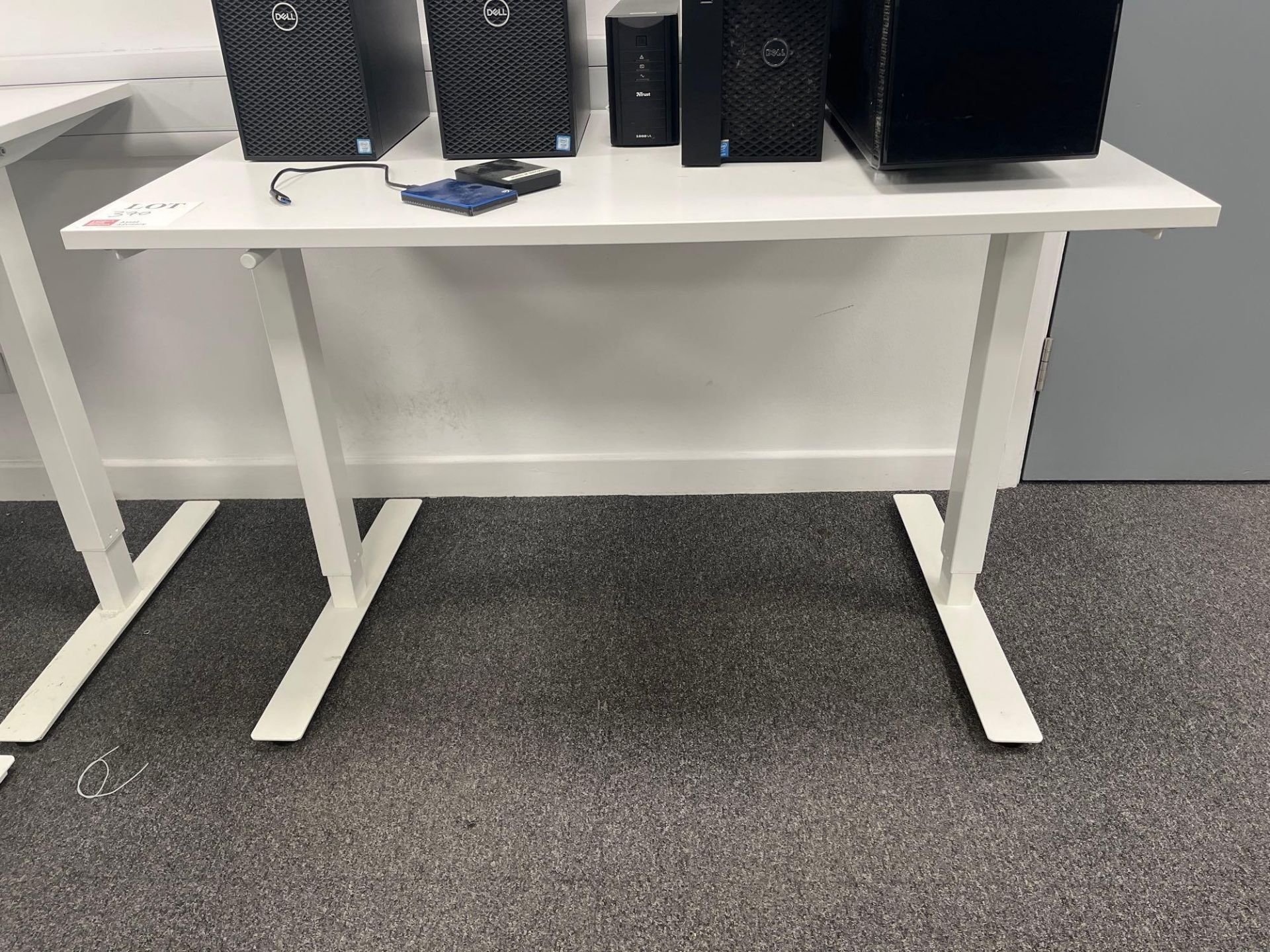 Three white adjustable height desks (excludes contents) (approximately 120cm L x 70cm W)