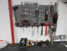 Wall mounted tool board with contents including spanners, mallets, staple gun, pliers, spirit level,