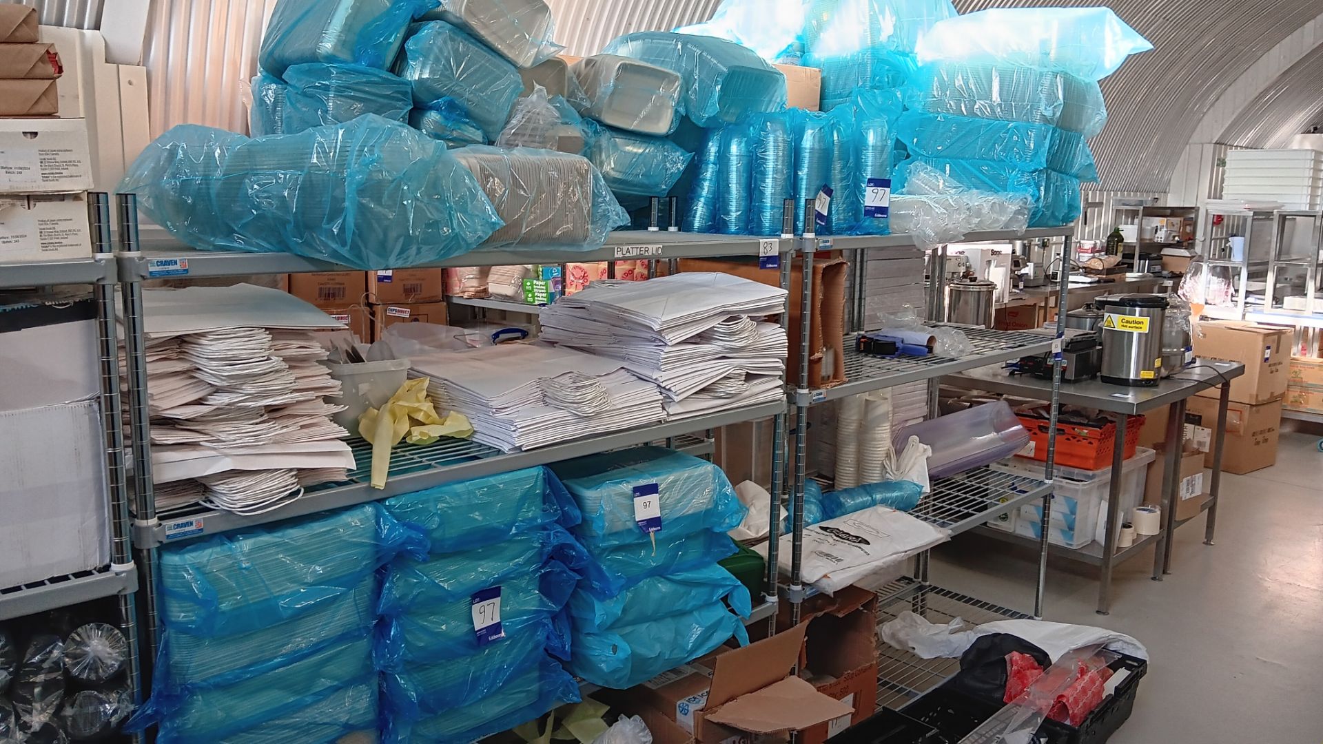 Contents of 2 racks of various packaging and consumables to include white paper bags, plastic and