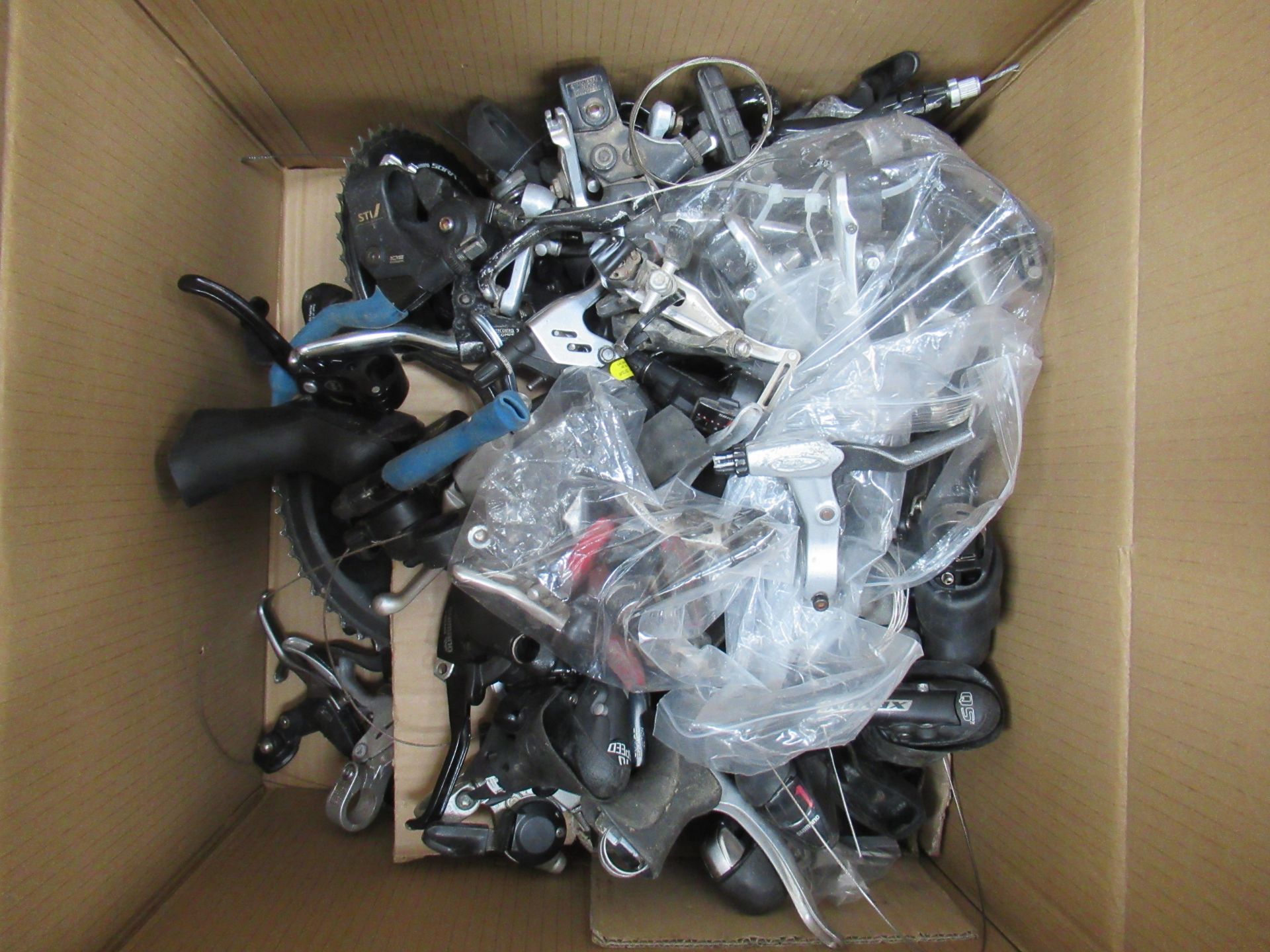 Contents of box including assorted used cycling parts and accessories