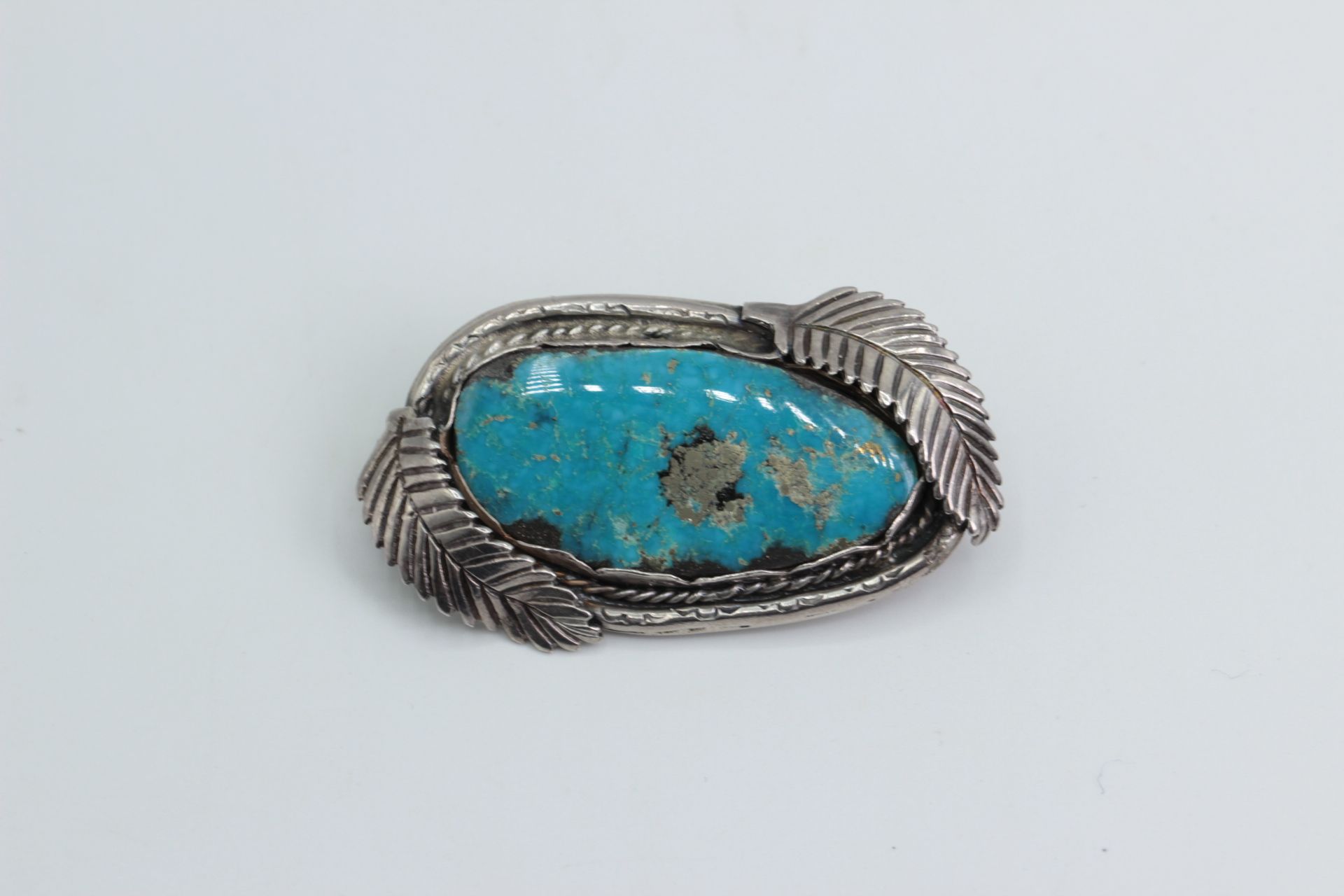 Silver brooch with a large turquoise. Indian jewelry USA