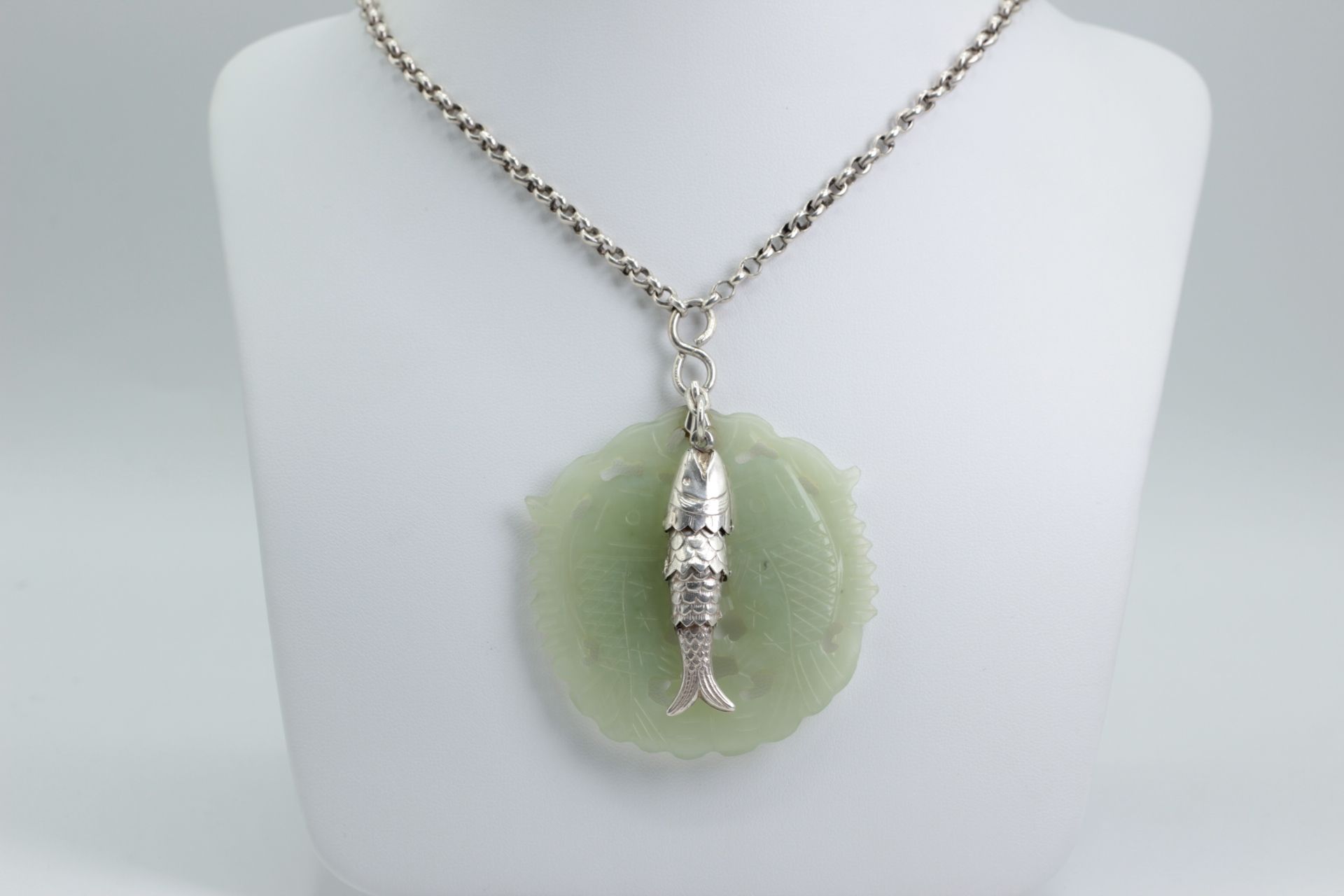 Silver necklace with a fish pendant and a Jadeit pendant. Symbols for luck