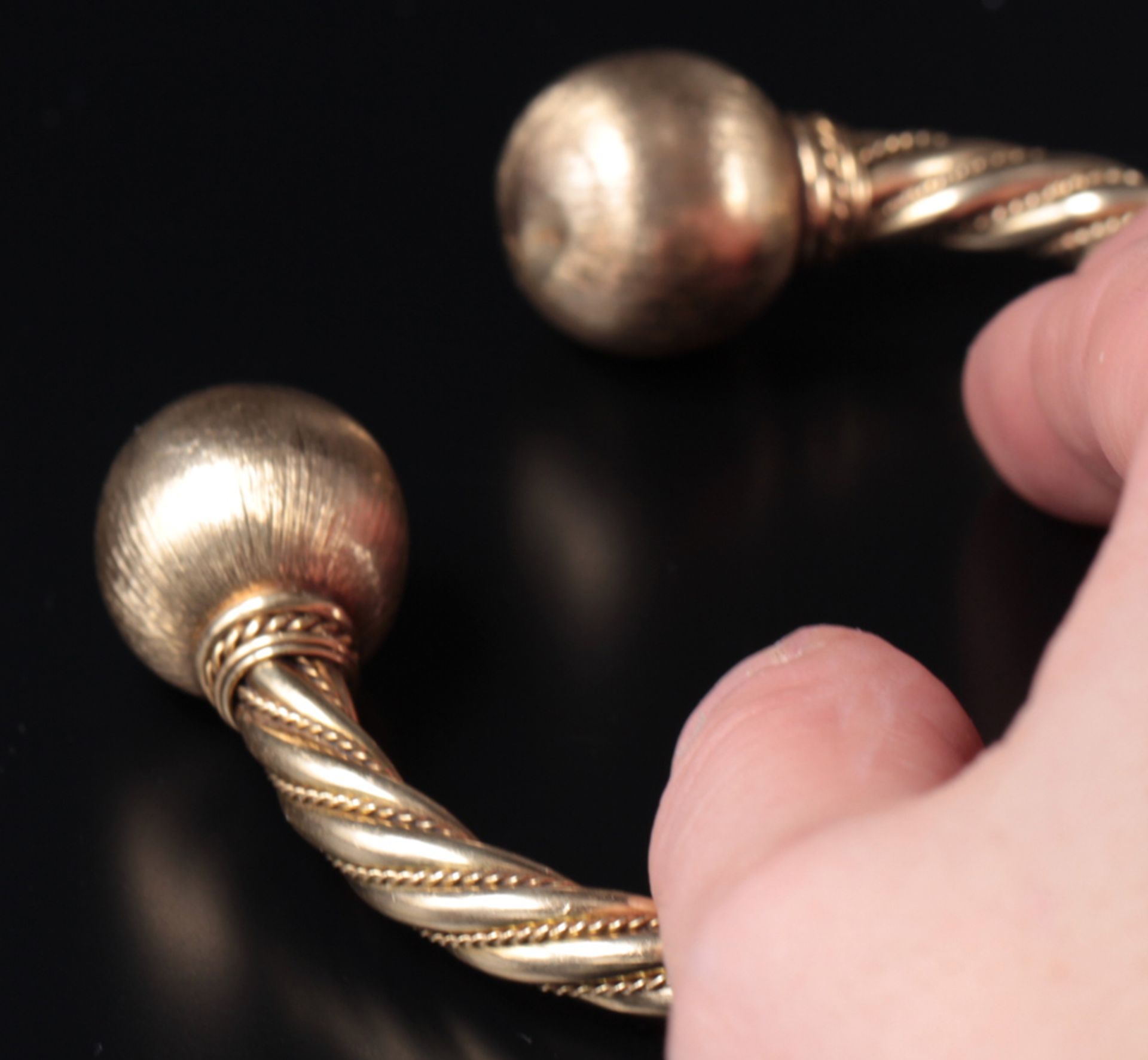 The bangle is made of twisted gold wires and has round spheres at the end.The spheres have a - Image 4 of 4