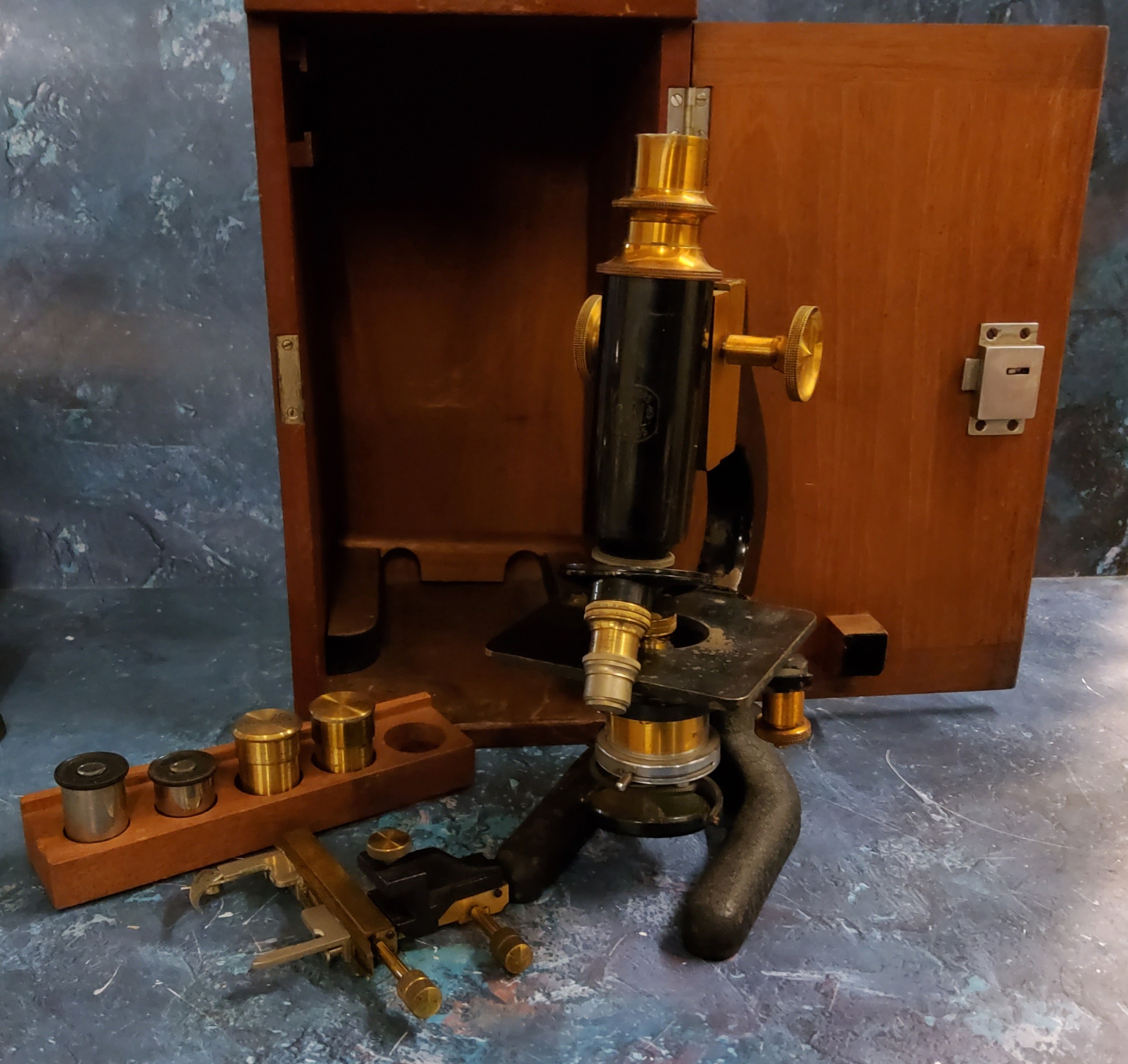 An Edwardian brass and cast iron microscope, marked Makers R  & B Ltd Leeds, with accessories,