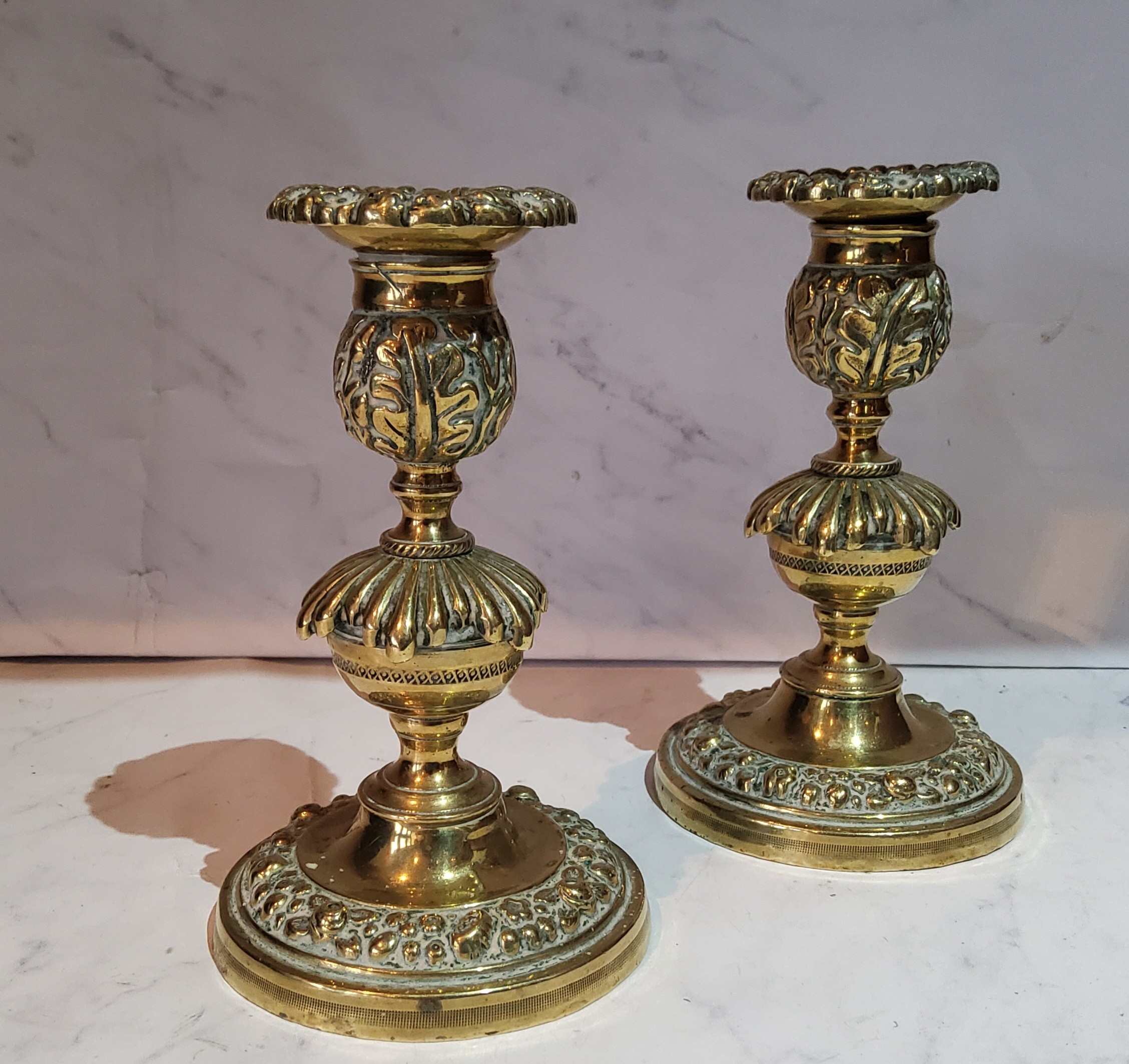 A pair of post Regency bronze candlesticks, the sconces cast with floral border, knopped stems,