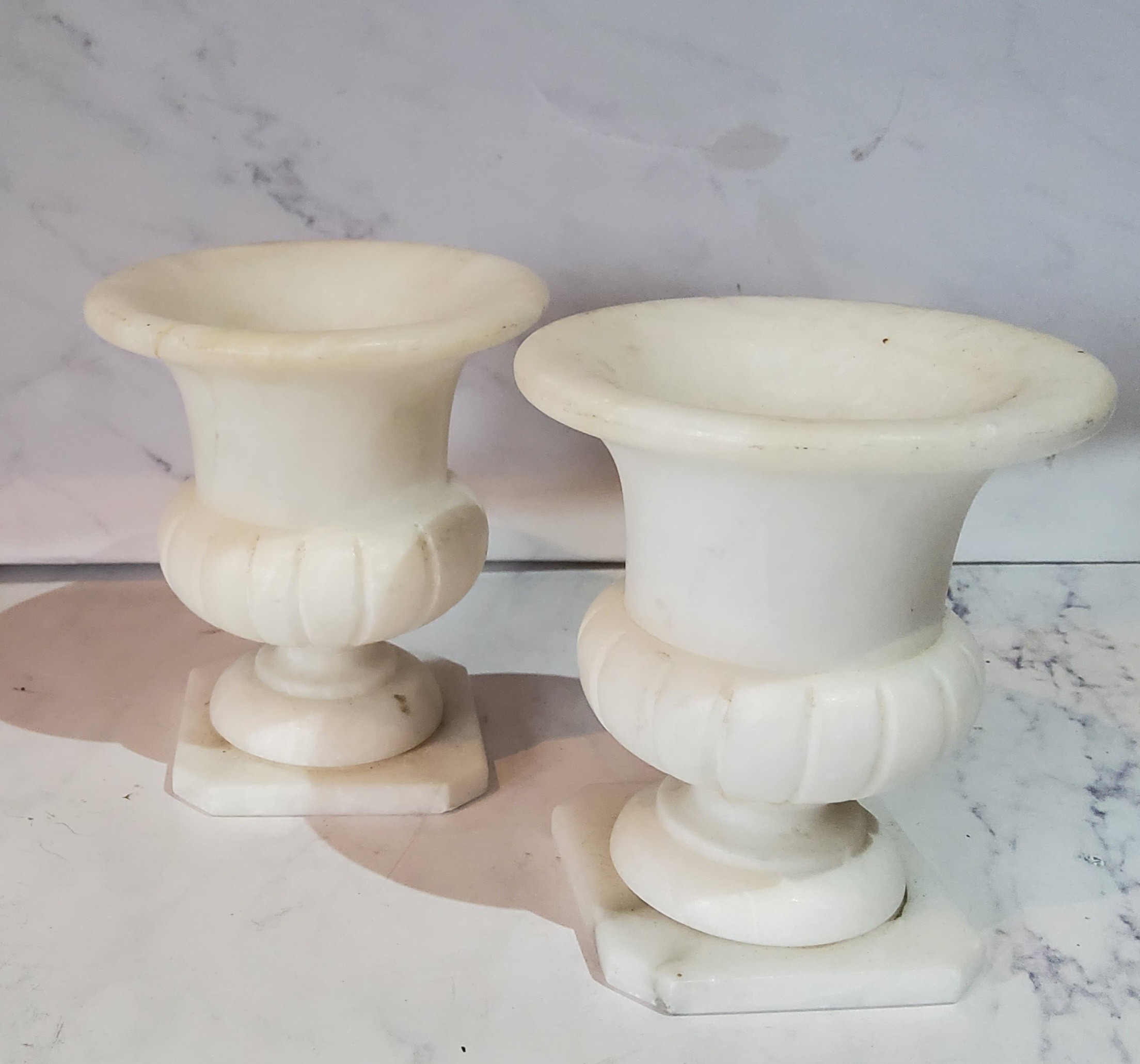 A pair of Italian alabaster miniature campana shaped vases, canted square bases, 8cm high