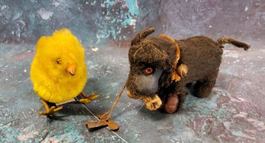 A Schuco clockwork Scottie Dog, holding a sock, 10cm long;    a clockwork chicken (2)