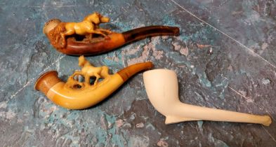 A Victorian meerschaum pipe, carved with a horse, amber mouth piece;  another;  a clay pipe (3)