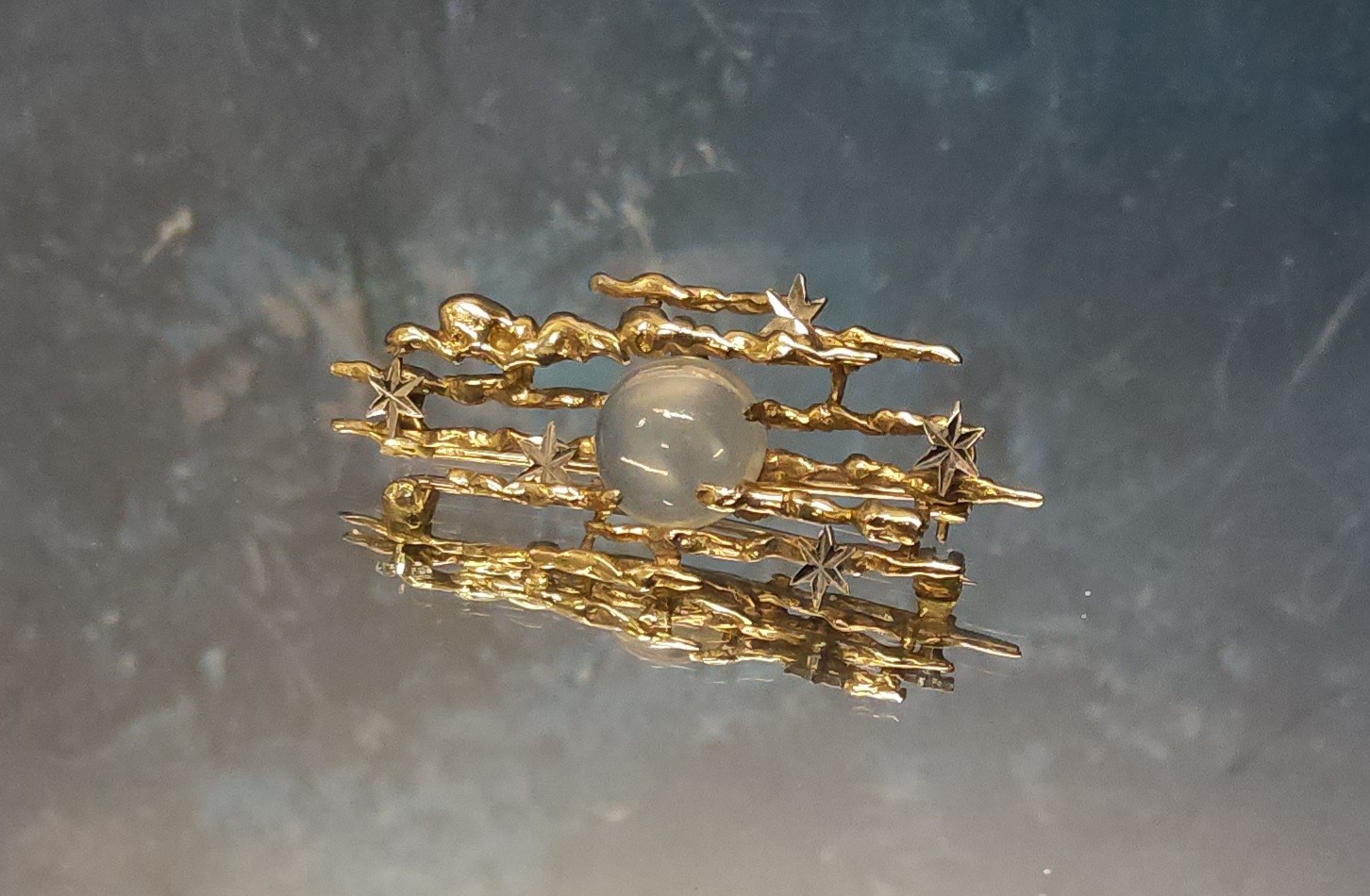 An unusual 9ct gold brooch in the form of the night sky, the seven gold bars in the form clouds