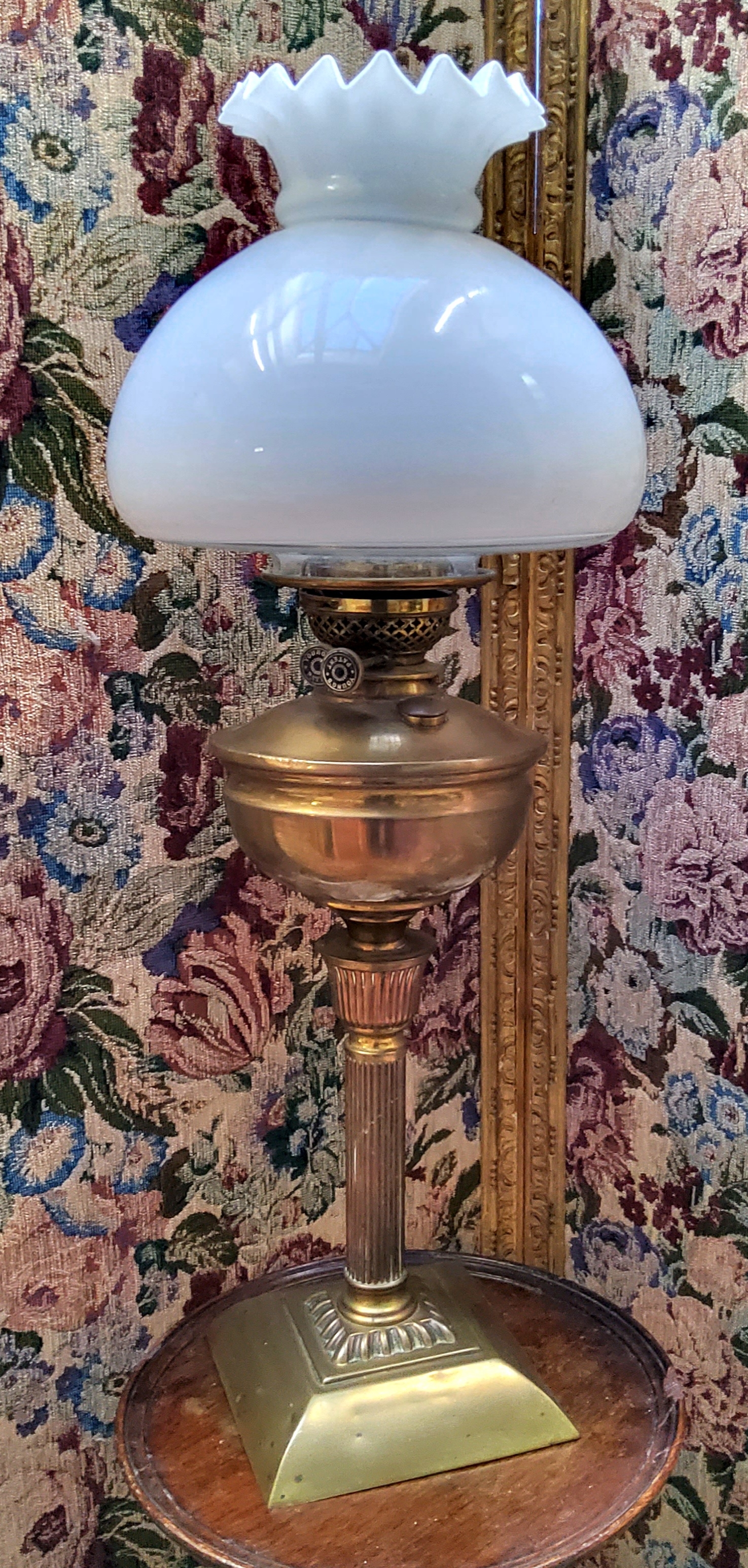 A Young's patent oil lamp, frosted Hassop shade above polished brass reservoir, turned fluted column