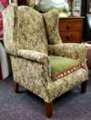 A Howard & Sons style wingback armchair, heavy gauge tapestry upholstery, mahogany feet