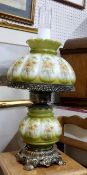 A vintage oil lamp, cast metal mounts with transfer printed glass reservoir and shade in green and