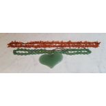 A Chinese jade bead necklace, heart shaped pendant, 27cm long;  a coral necklace (2)