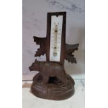 An early 20th century Black Forest thermometer, the base with a bear, inscribed Lugano, 18cm high,